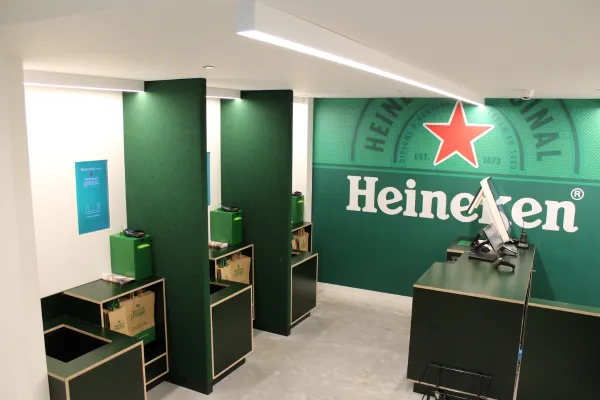 Innovative RFID-powered self-checkout kiosk at the Heineken Experience shop, allowing visitors to scan and pay for souvenirs instantly without manual barcode scanning.